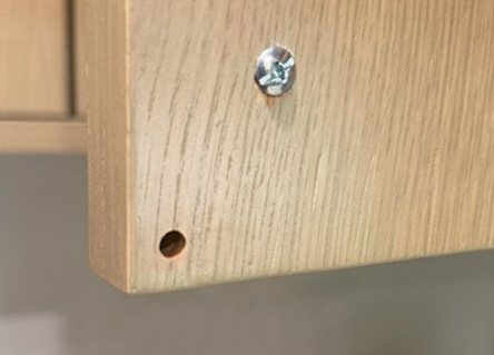 Drilled hole in the corner of a cabinet door